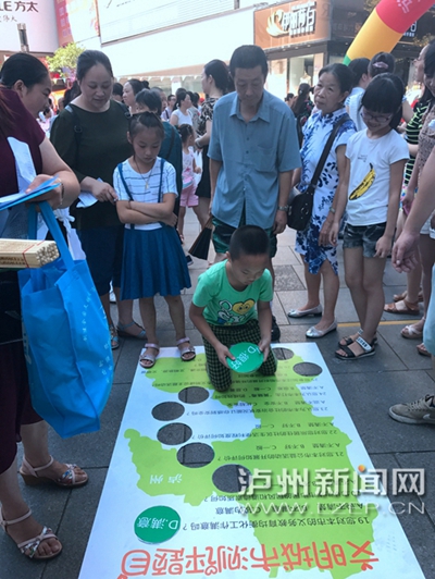 市民在宣傳點(diǎn)參加創(chuàng)文趣味游戲。 記者 朱虹 攝